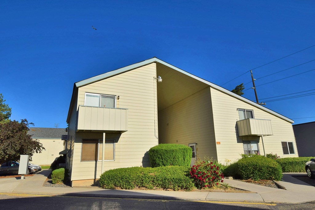A beige apartment building with a clear blue sky above.