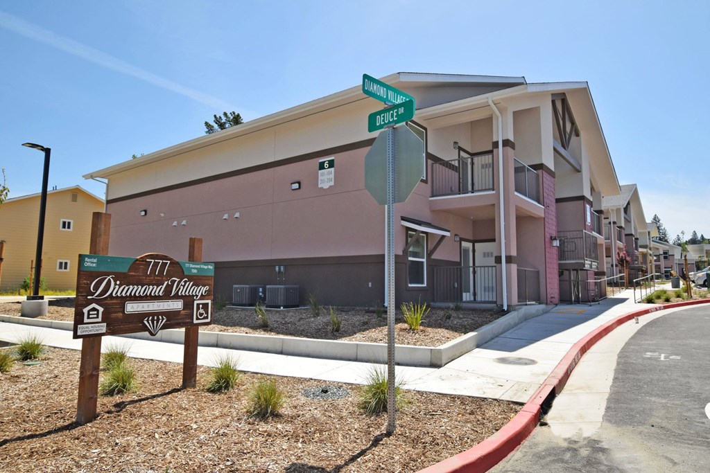 Diamond Village apartment complex with a street sign in front.