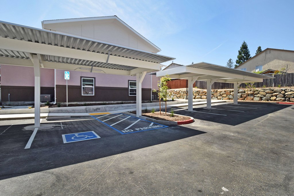 A parking lot with a covered area and a handicap parking space.