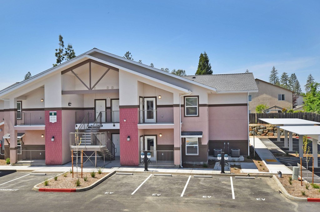 A modern building with a parking lot in front.