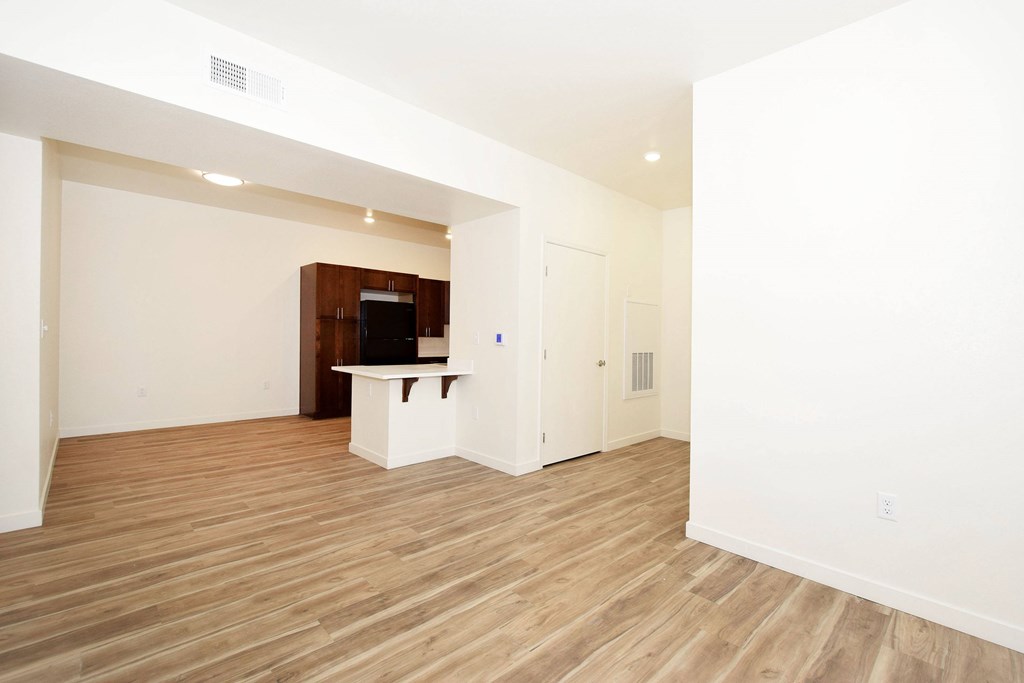 A room with a wooden floor and a television on a cabinet.
