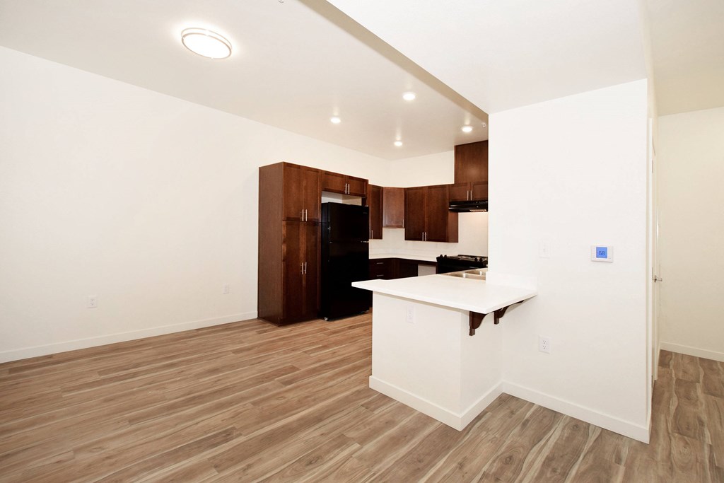 A kitchen area with a white counter and brown cabinets.