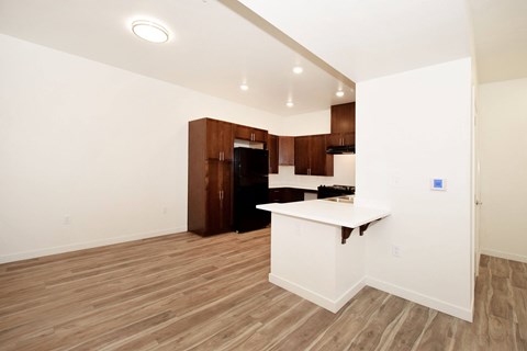 A kitchen area with a white counter and brown cabinets.