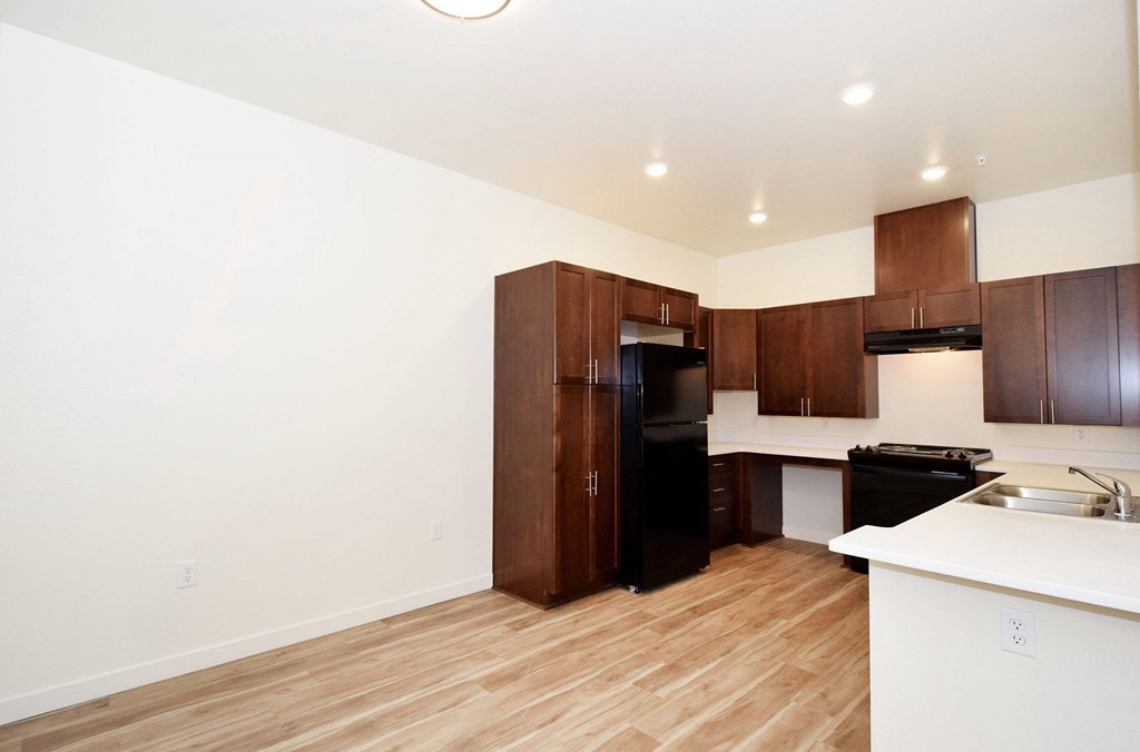 A kitchen with wooden floors and white walls.