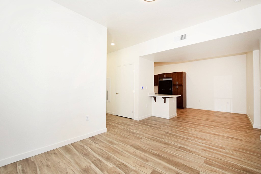 A room with a wooden floor and a television on a cabinet.