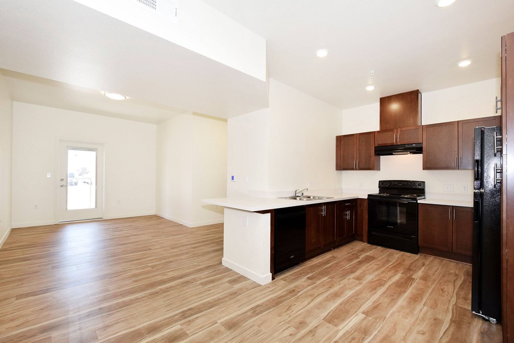 A kitchen with wooden floors and white walls.
