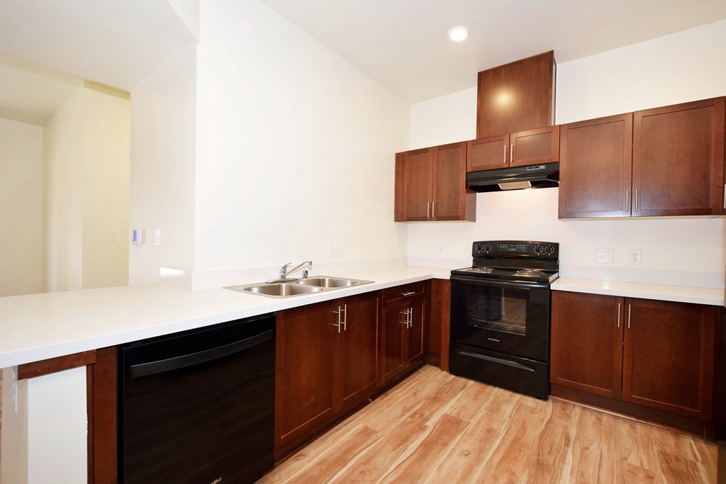 A kitchen with wooden cabinets and a black oven.