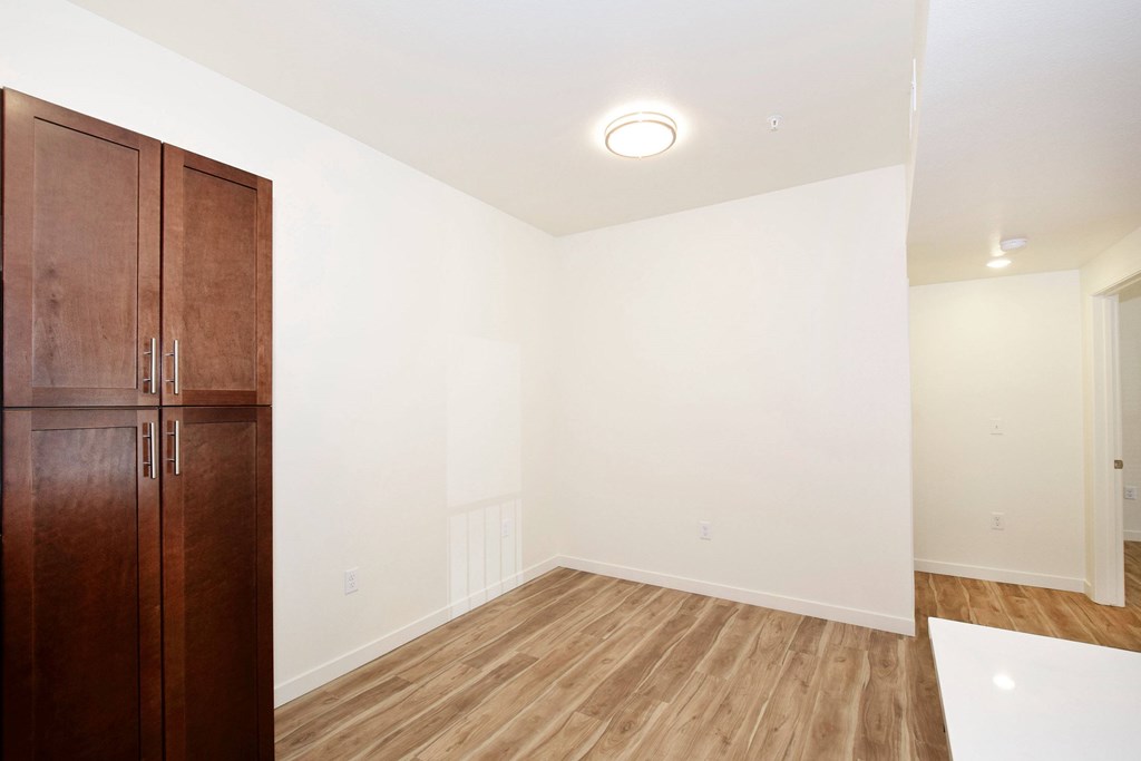 A room with a wooden floor and a brown cabinet.