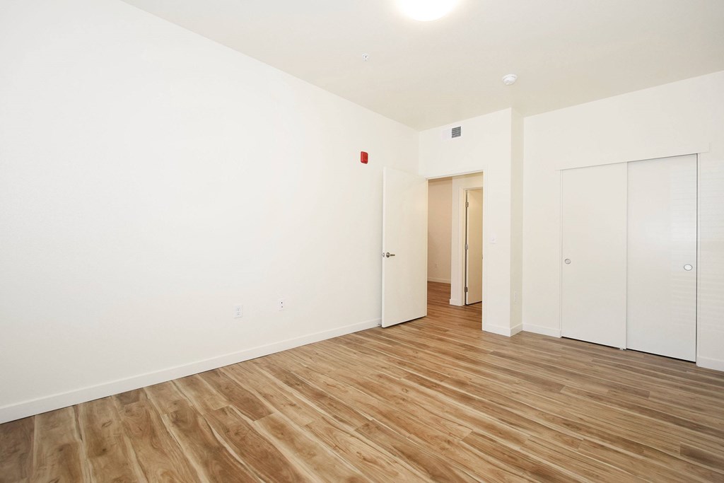 A room with wooden flooring and white walls.