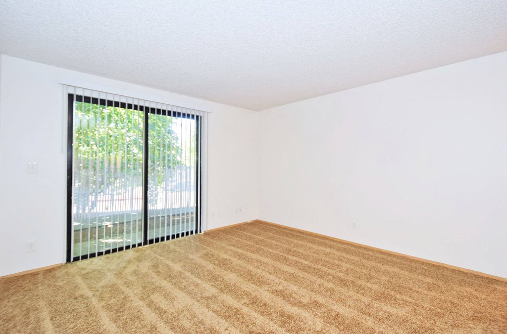 a bedroom with a large window and white walls