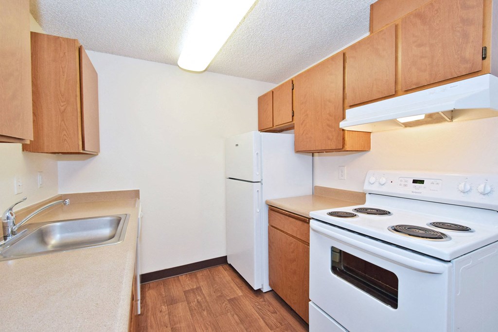 a kitchen with white appliances and wooden cabinets