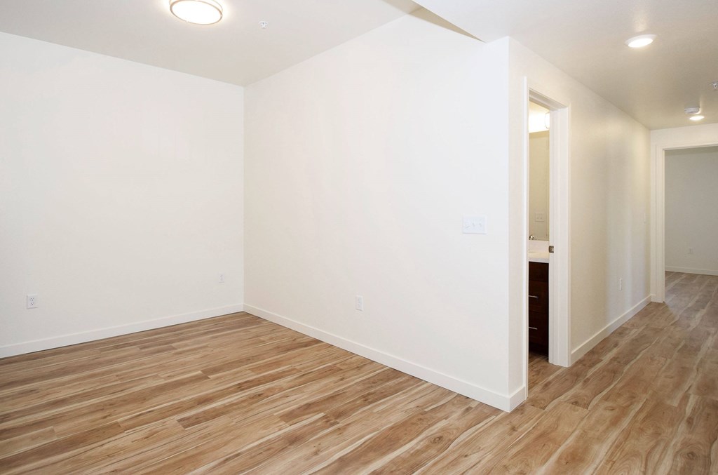 A room with wooden flooring and white walls.