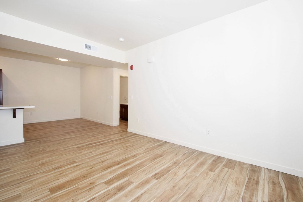 A room with wooden flooring and white walls.