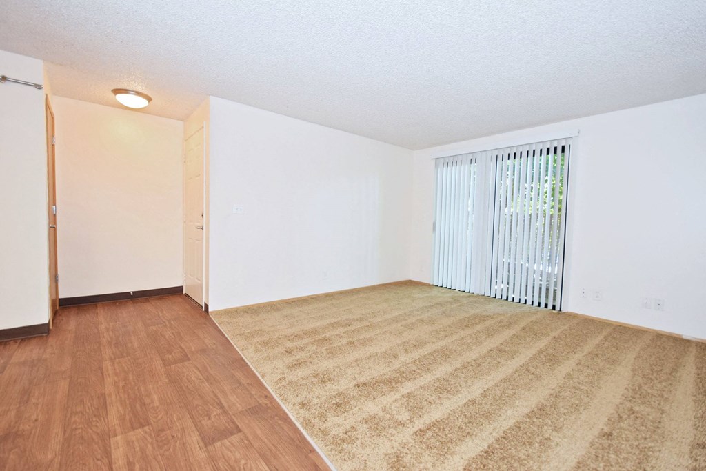 a bedroom with hardwood floors and white walls