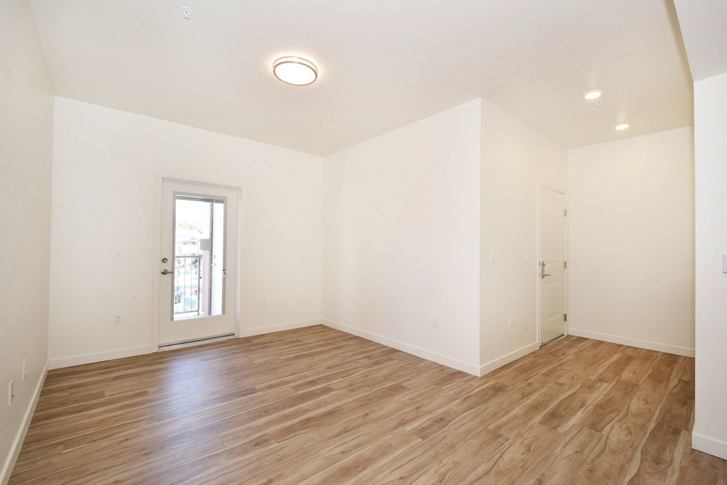 A room with wooden flooring and a sliding glass door.