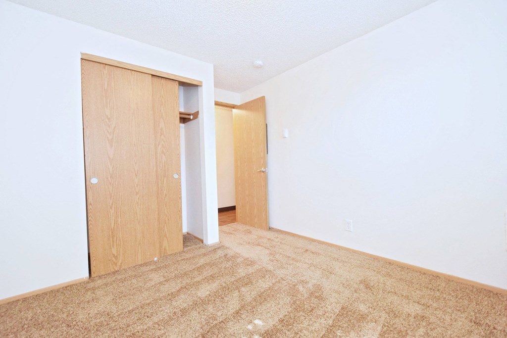 a bedroom with an open door and a carpeted floor