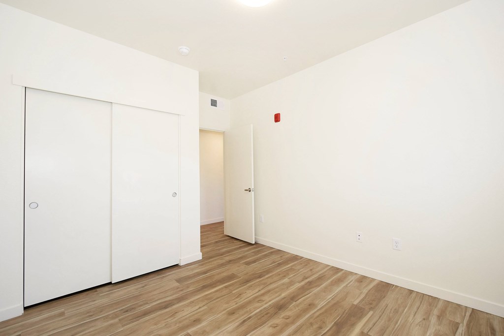 A room with a white wall and a wooden floor.