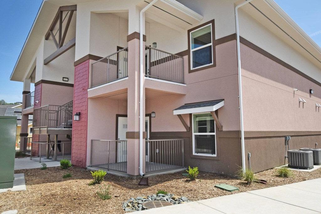 A two-story apartment building with a balcony on the second floor.