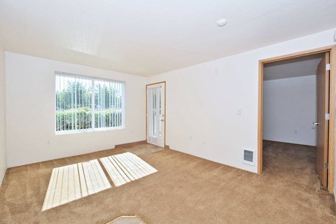 the living room of a house with a large window and a door