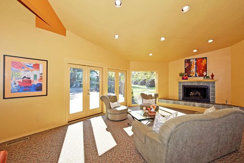 A living room with a grey couch and a fireplace.
