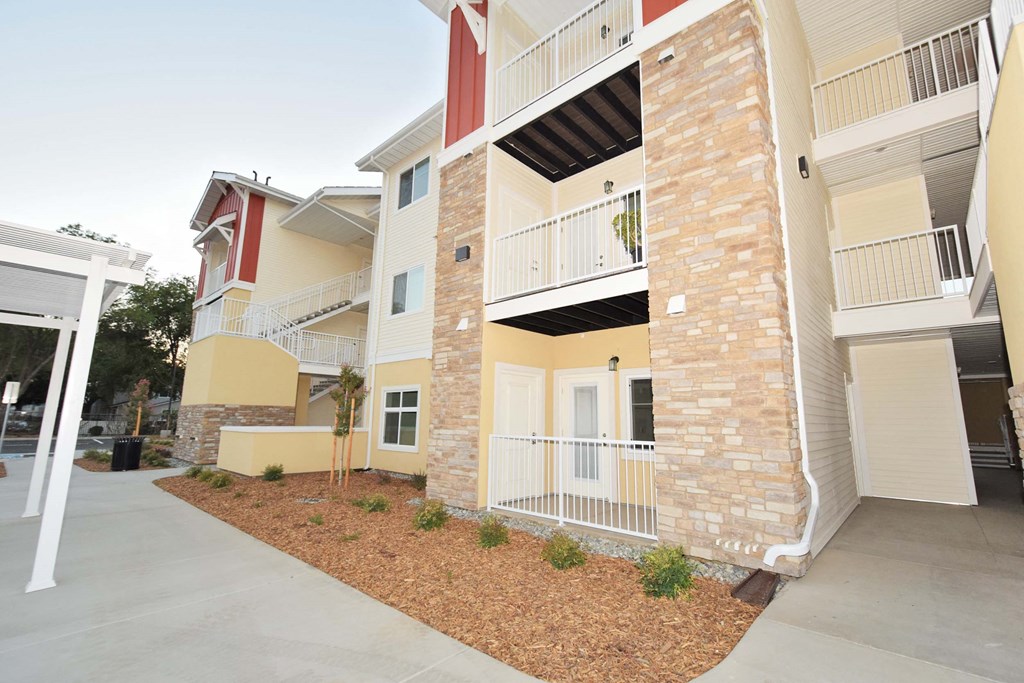 an exterior view of an apartment building with a sidewalk