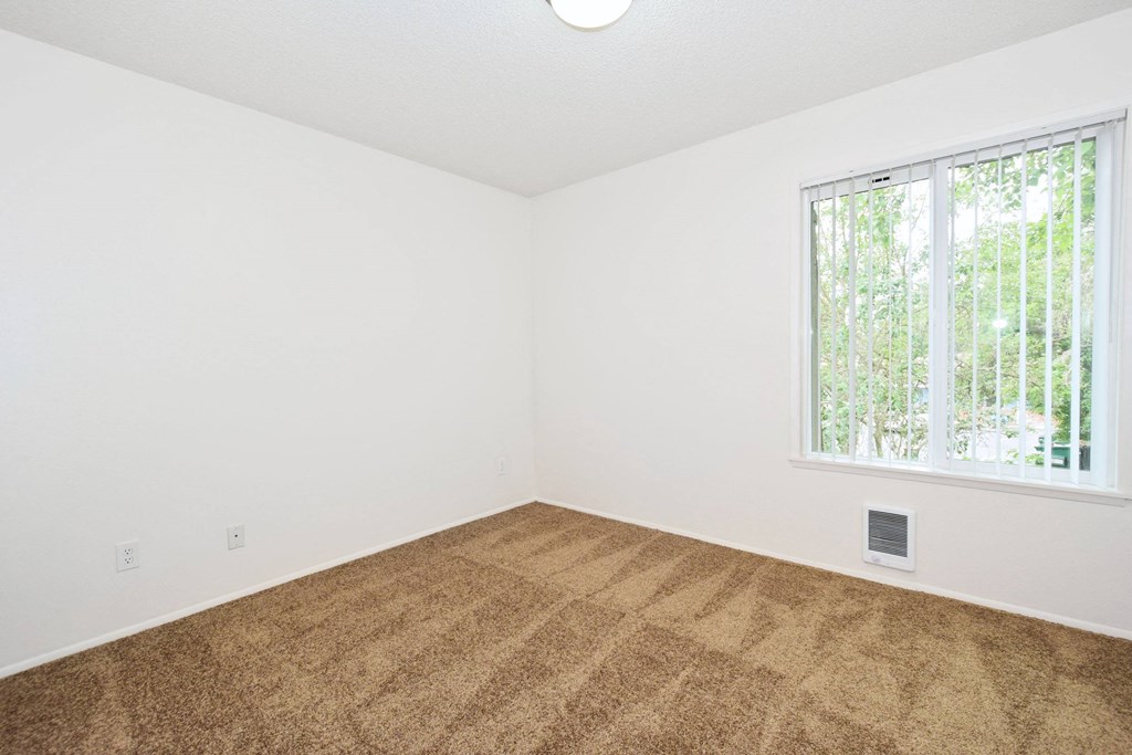 an empty room with carpet and a window