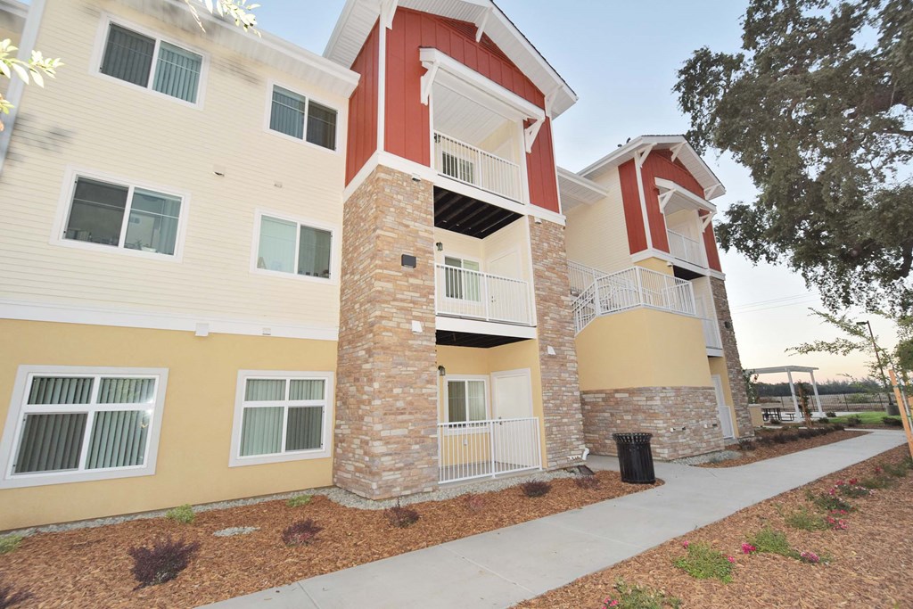 a building with two stories and a sidewalk in front of it