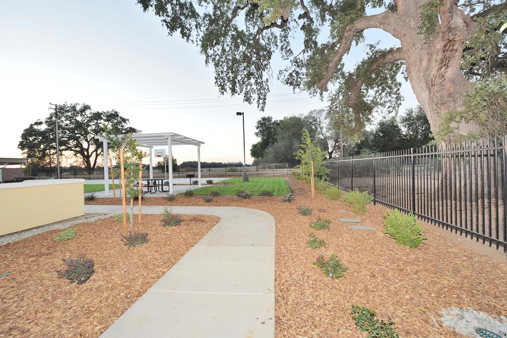 a sidewalk leading to a park with a gazebo