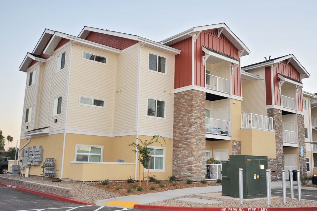 a street view of three story apartment buildings with balconies