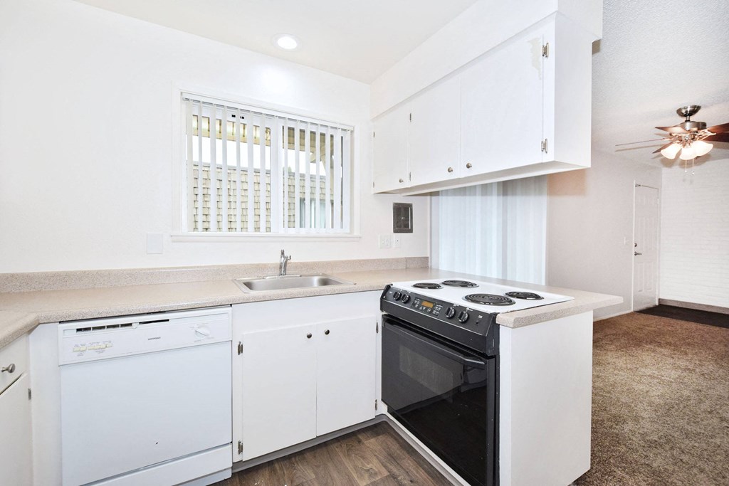 a kitchen with white cabinets and a stove and a sink