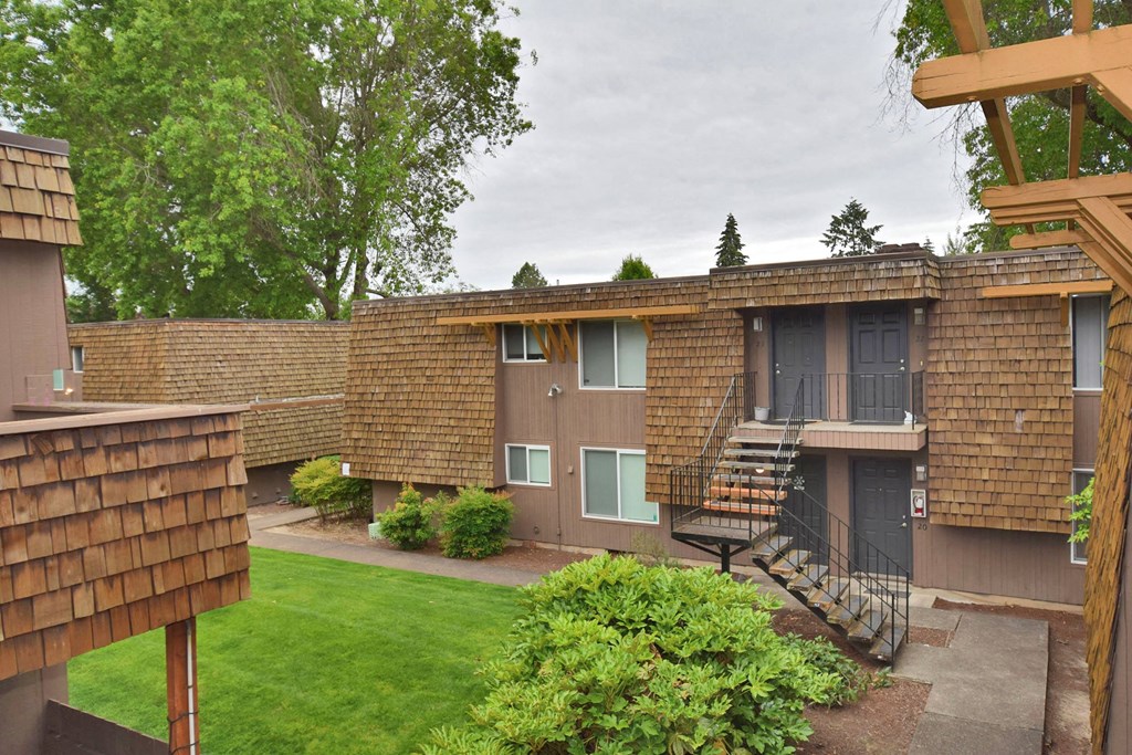 an exterior view of a building with a yard and stairs