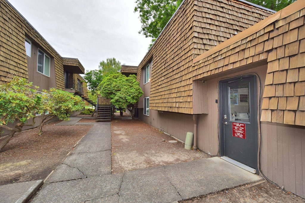 the side of a building with a sidewalk and a door
