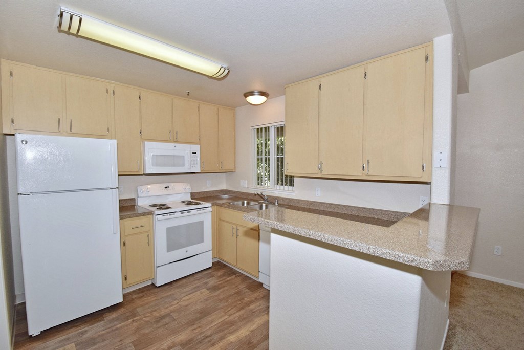 a kitchen with white appliances and a granite counter top