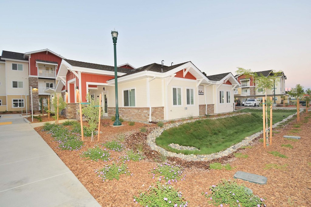 a group of houses in front of a yard with grass