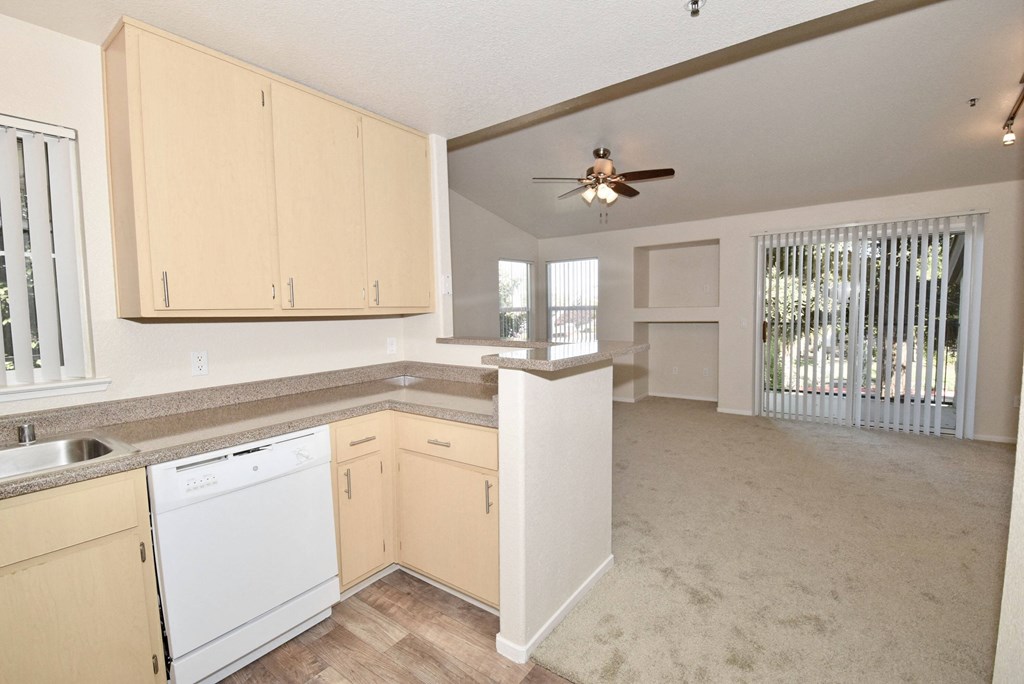 an empty kitchen with white cabinets and a ceiling fan