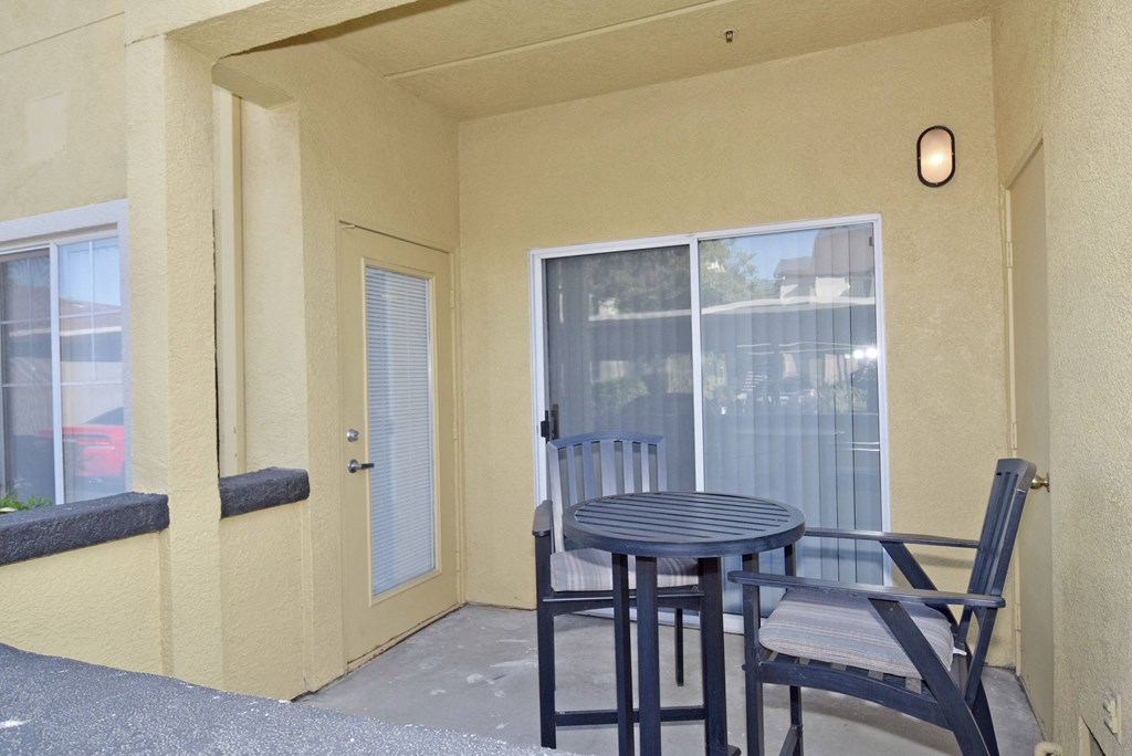 a patio with a table and chairs and a door
