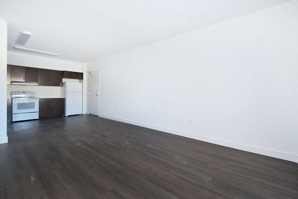 an empty living room with white walls and wooden floors