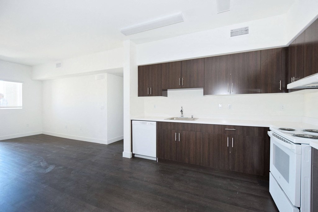 an empty kitchen with white appliances and wooden cabinets