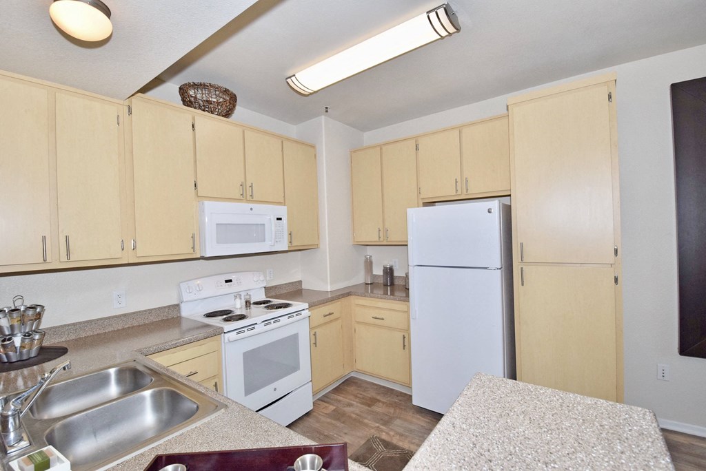 a kitchen with white appliances and wooden cabinets