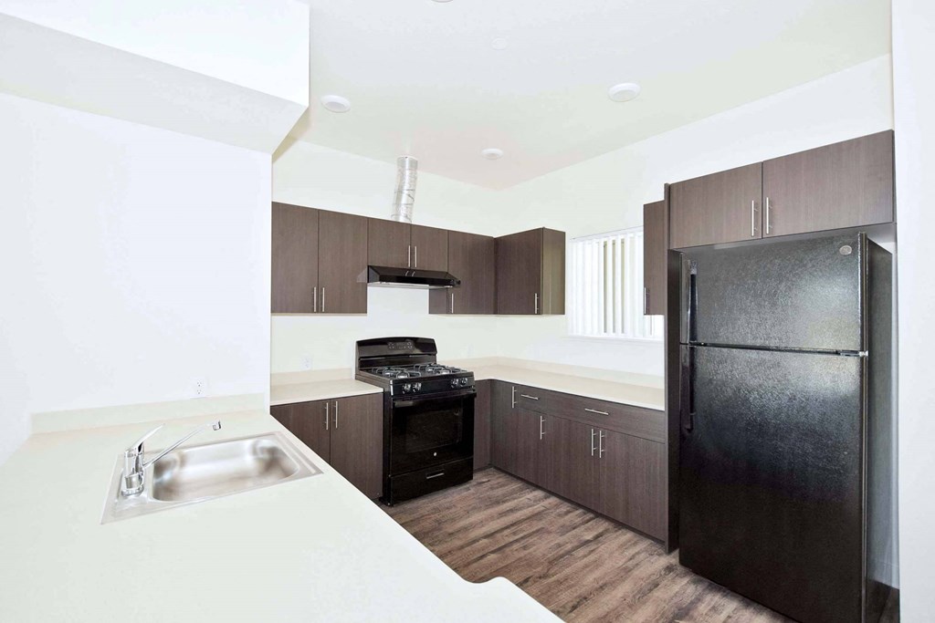 a kitchen with white countertops and dark wood cabinets