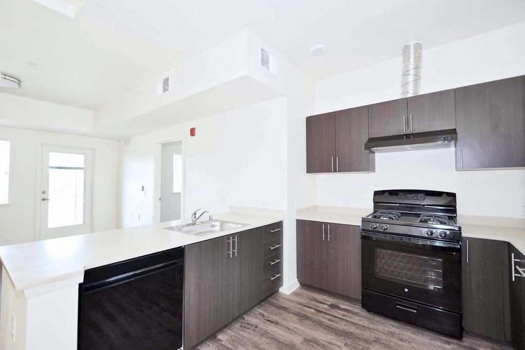 a kitchen with white countertops and dark wood cabinets