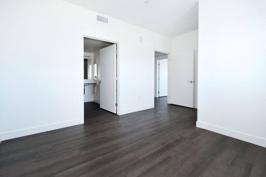 an empty living room with white walls and wood floors