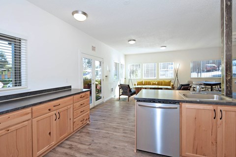 A kitchen with wooden cabinets and a stainless steel dishwasher.