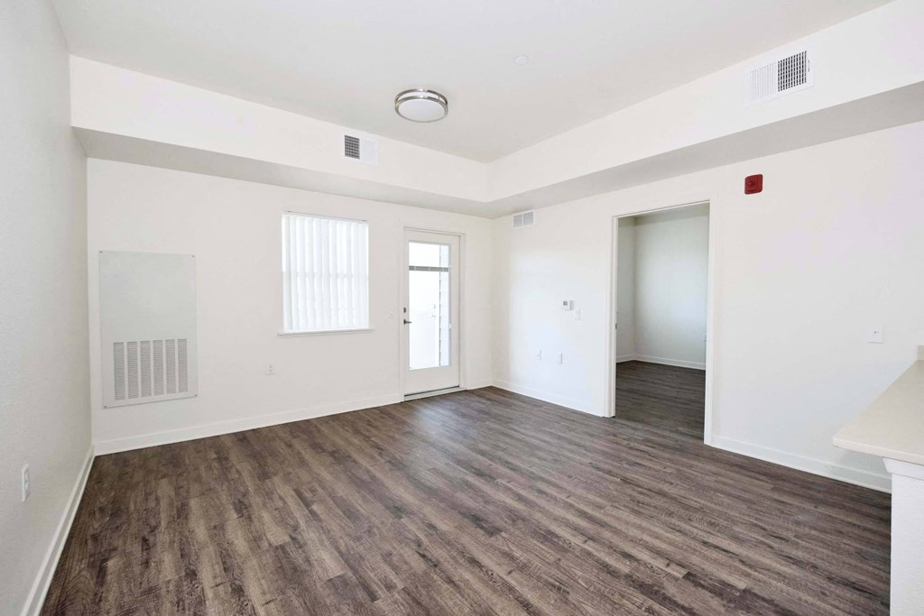 a bedroom with hardwood floors and white walls