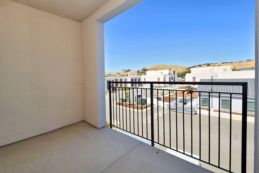 a balcony with a view of a parking lot and a blue sky