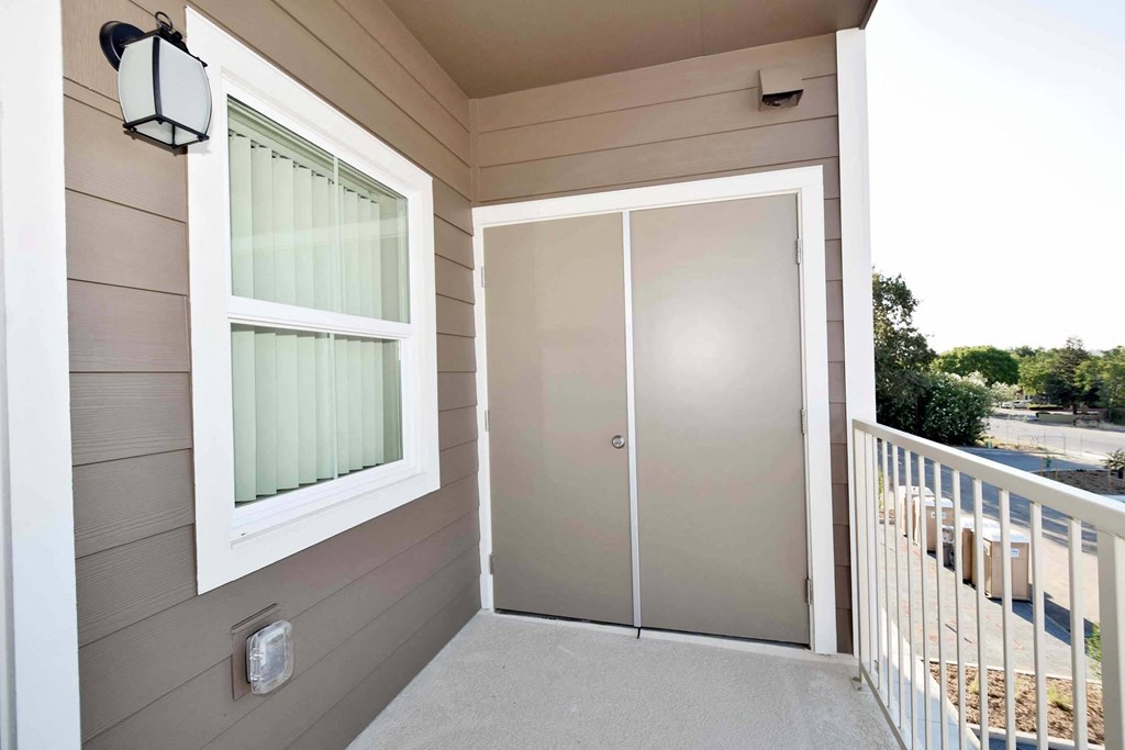 a front porch with a glass door and a large window