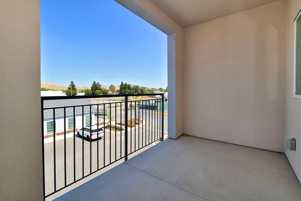 the spacious balcony has a view of the pool and the patio