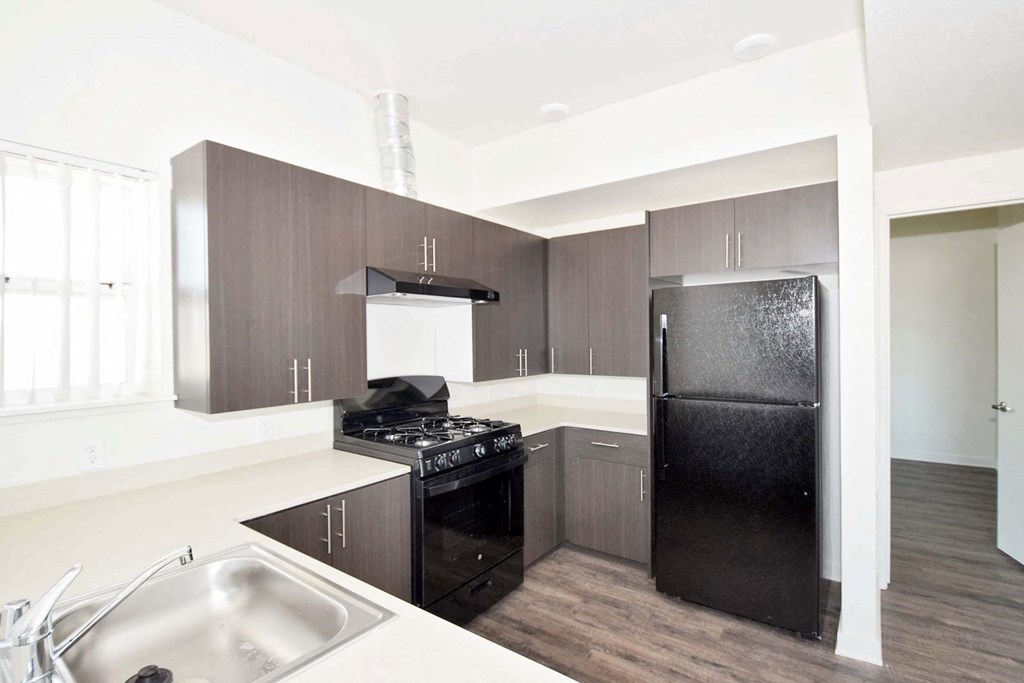 a kitchen with black appliances and white countertops