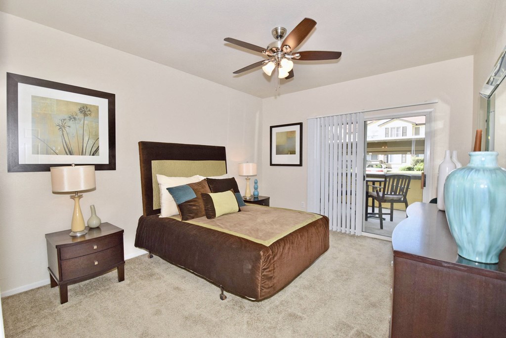 a bedroom with a bed and a ceiling fan