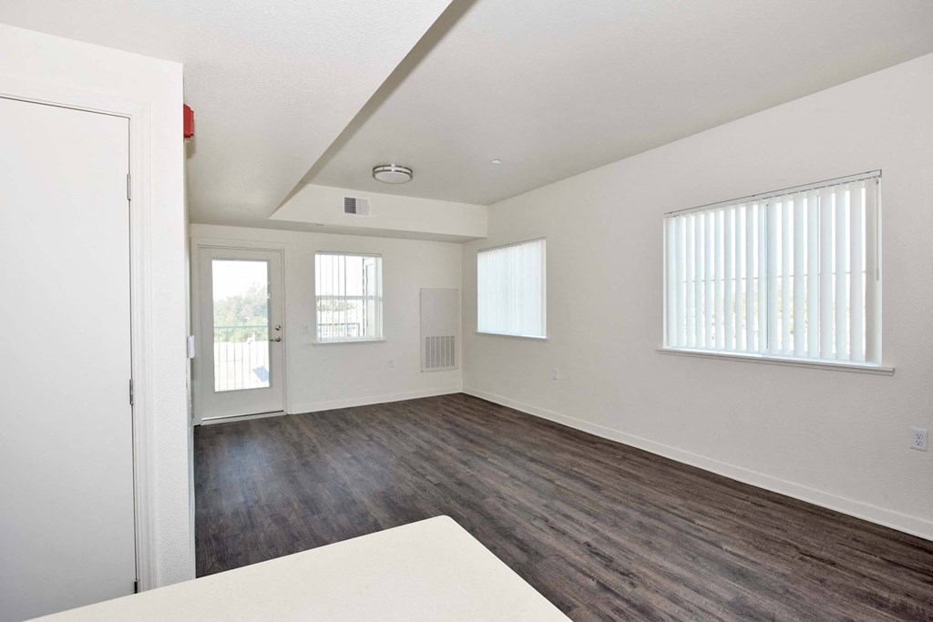a bedroom with hardwood floors and white walls